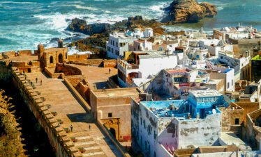 Essaouira beach view from the medina" "Goats climbing Argan trees in Morocco" "Seaside lunch in Essaouira" "Historic ramparts of Essaouira Kasbah" "Traditional Moroccan art in Essaouira"