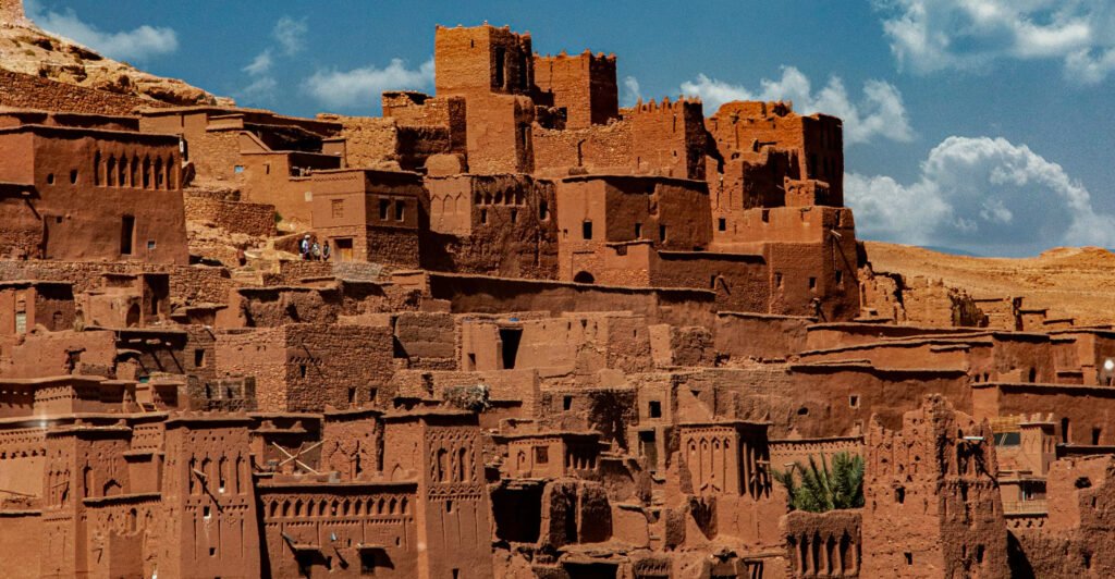 Hidden riad courtyard discovered during a Medina Secrets tour Tourists exploring narrow alleys of Marrakech medina with guide Traditional Moroccan tiles and fountain in a secret medina garden Local artisan crafting leather goods in a Marrakech souk Interior of a restored caravanserai in the old medina Guide explaining medina history in front of ancient wooden door Colorful spice market in the heart of the medina View of hidden rooftop terrace overlooking Marrakech medina morocco travel bliss