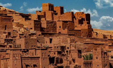 Hidden riad courtyard discovered during a Medina Secrets tour Tourists exploring narrow alleys of Marrakech medina with guide Traditional Moroccan tiles and fountain in a secret medina garden Local artisan crafting leather goods in a Marrakech souk Interior of a restored caravanserai in the old medina Guide explaining medina history in front of ancient wooden door Colorful spice market in the heart of the medina View of hidden rooftop terrace overlooking Marrakech medina morocco travel bliss