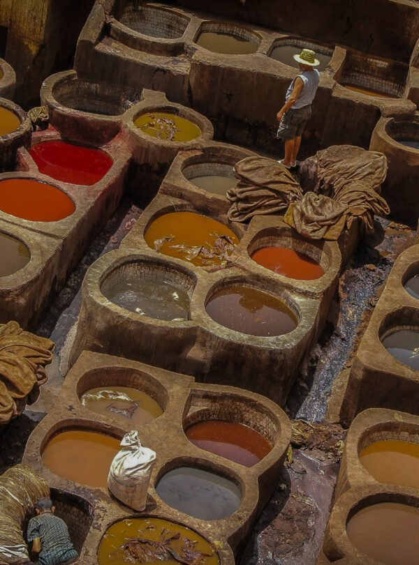 Hidden riad courtyard discovered during a Medina Secrets tour Tourists exploring narrow alleys of Marrakech medina with guide Traditional Moroccan tiles and fountain in a secret medina garden Local artisan crafting leather goods in a Marrakech souk Interior of a restored caravanserai in the old medina Guide explaining medina history in front of ancient wooden door Colorful spice market in the heart of the medina View of hidden rooftop terrace overlooking Marrakech medina morocco travel bliss