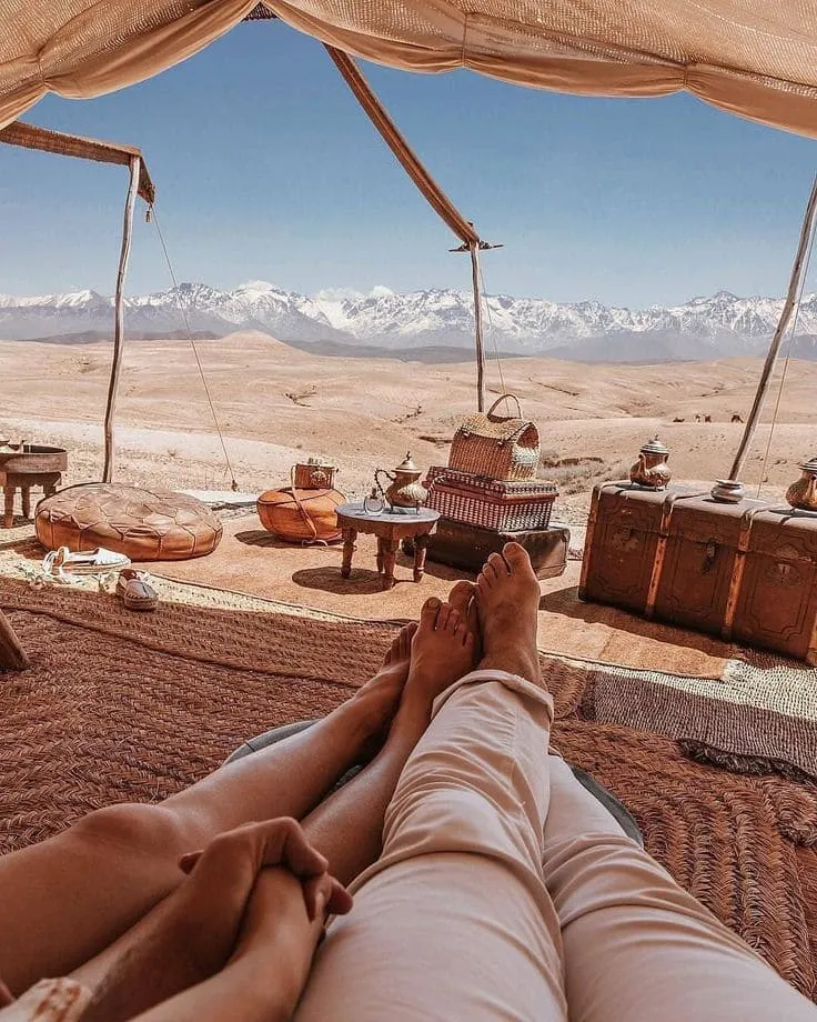 Agafay Desert View with Atlas Mountains in the Distance Couple relaxing at Agafay desert camp overlooking the snow-capped Atlas Mountains, Morocco